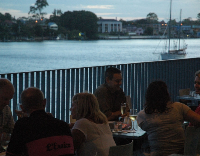 Diner sitting on Bar Alto's balcony looking over Brisbane River