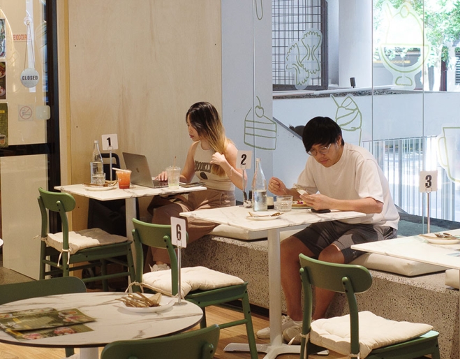 Customers sitting in window of Mitr Dessert House