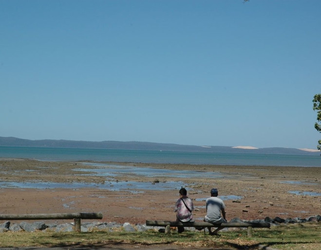 Couple sitting on bench in Harold Walker Park Cleveland looking at the ocean. 