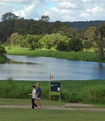 Minnippi Parklands  Couple walking along foot and cycle path in Minnippi Parklands next to lagoon.
